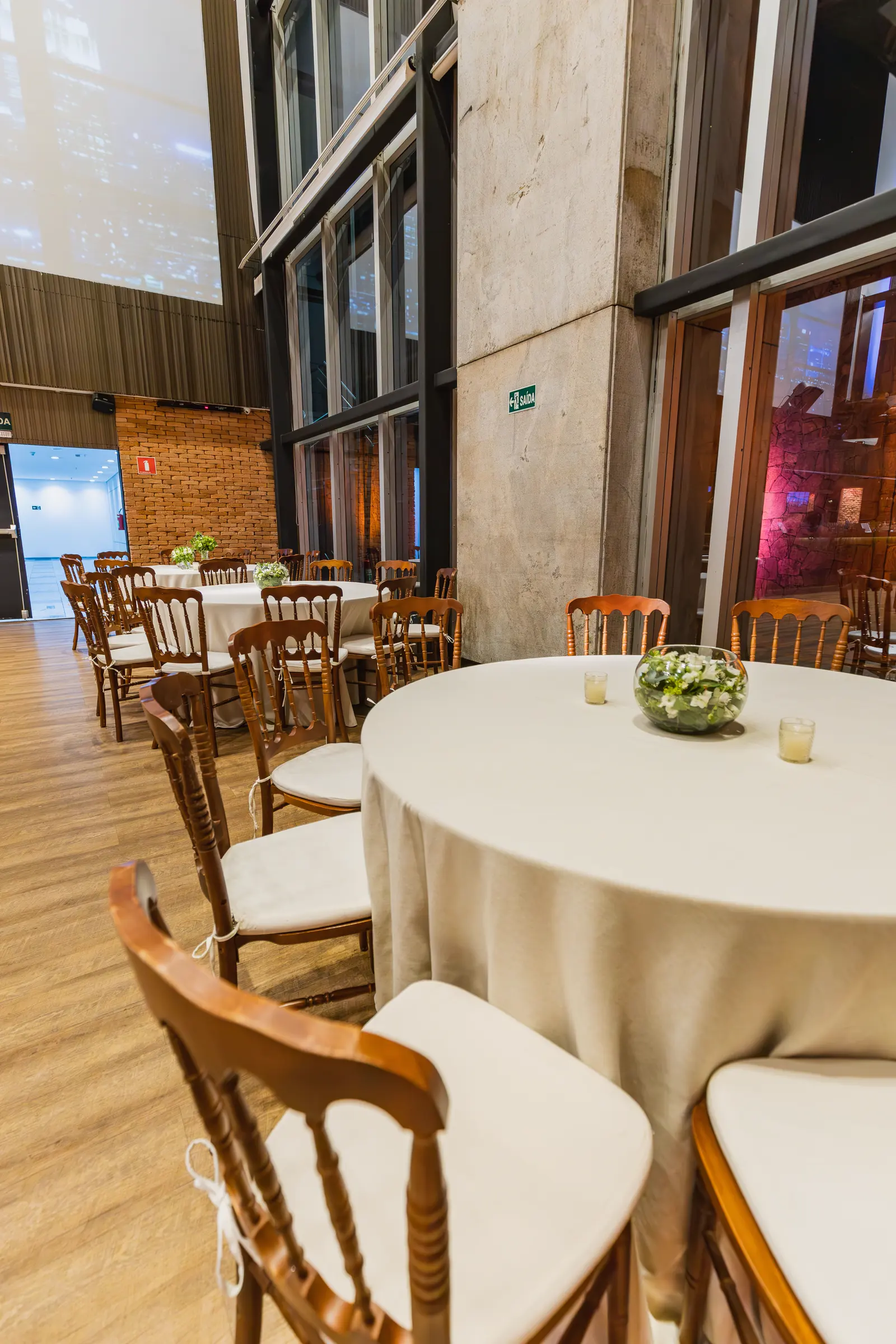 Mesa redonda de banquete montada con mantelería, cristalería y centro de mesa.